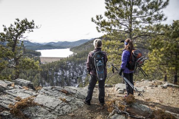 two hikers with snowshoes ready out exploring the views of the black hills near sheridan lake