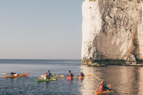 A group of kayaks at the base of Old Harry Rocks