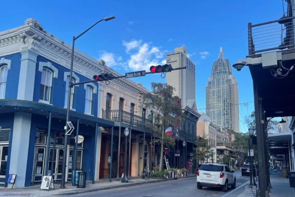 A street lined with historic buildings and two skyscrapers in the background