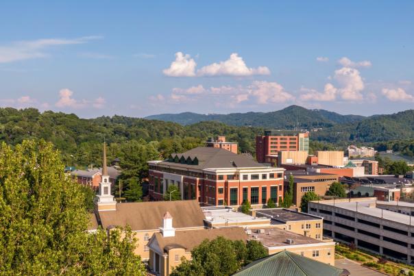 From an aerial perspective, several buildings on Appalachian State University's campus can be seen in the foreground with the rolling Blue Ridge Mountains in the background.