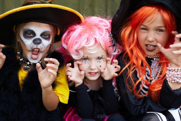 Three kids in Halloween costumes.