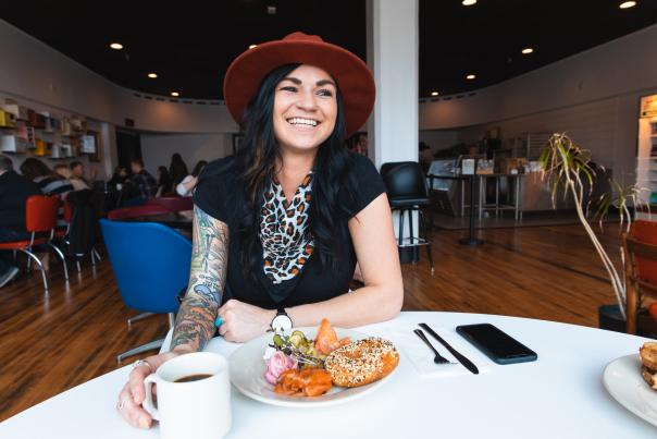 Erica Rapp at BernBaums smiling with a bagel and coffee