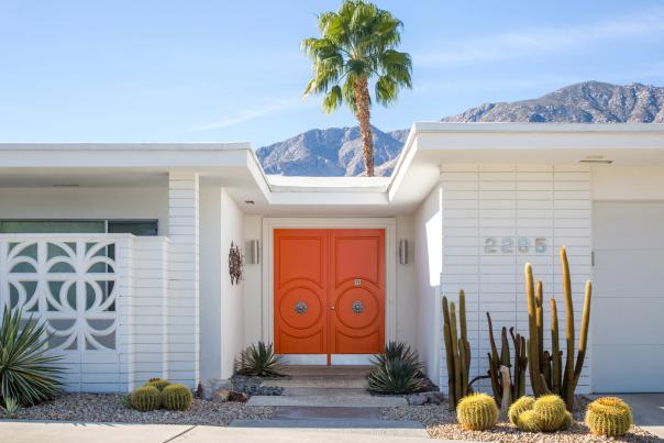 Modernism house with pretty palm tree background and orange door.