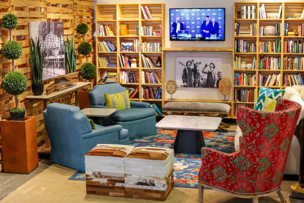 floor to ceiling wooden bookshelves, flat screen tv, cozy couches and music themed décor
