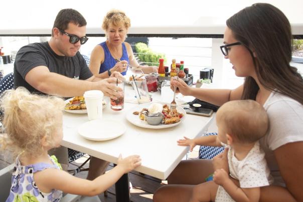 A family sits by the waterway, enjoying a delicious meal