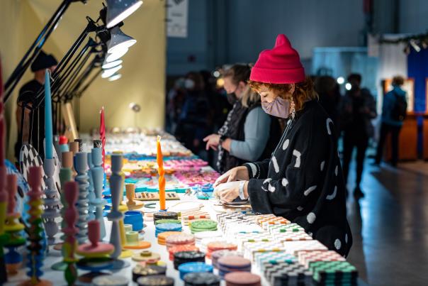 Vendor with products on a table at Toronto's One of a Kind Show