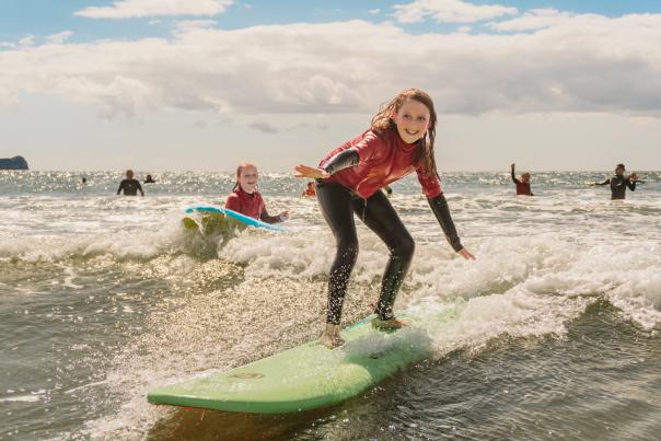 young girls surfing in rhossili bay
