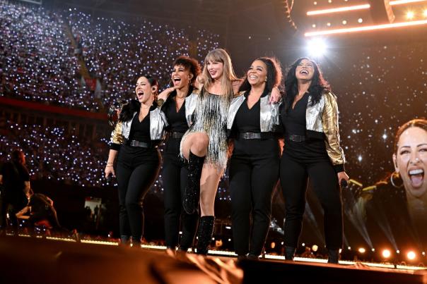 Taylor Swift during the Eras Tour with her backup singers on stage