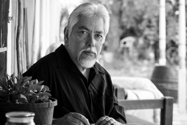 New Mexico Poet Laureate Levi Romero sits under the portal of his family's home in Dixon