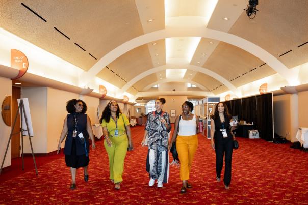 Five multicultural women walk through Monona Terrace Community and Convention Center during a mental health conference