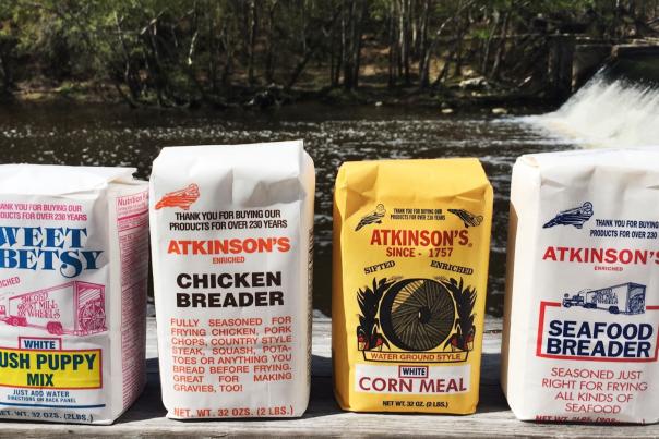 Atkinson Product Bags lined up in front of river and mill wheel in Selma, NC.