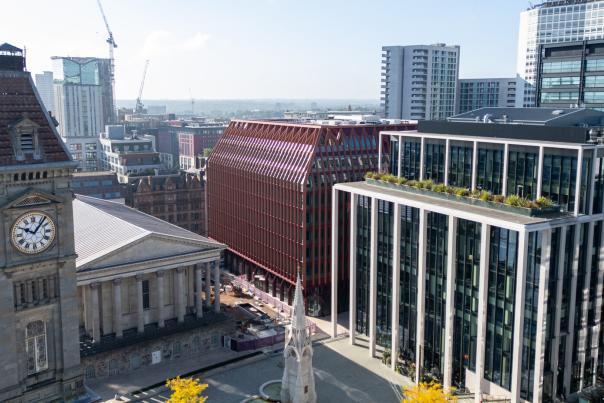 A view from high up looking down over Paradise in Birmingham. Cranes in the background work on construction projects within the city.
