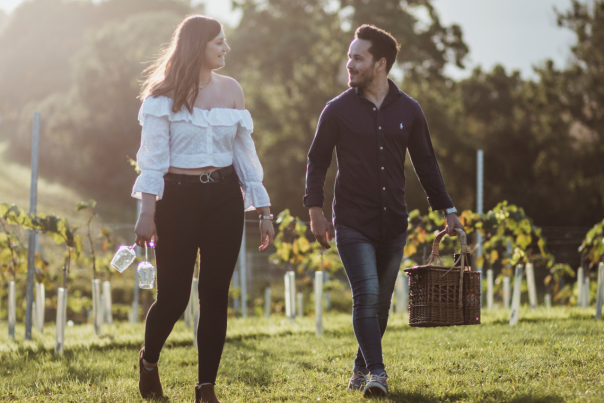 A couple walking with their picnic through the Wolds Vineyard