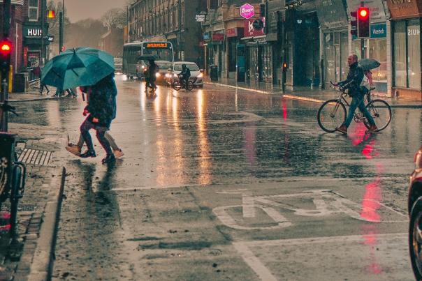 Elm Grove in Southsea in pouring rain, with people walking holding umbrellas