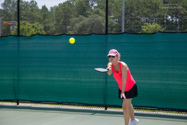 a woman serving a pickleball
