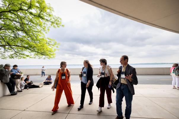 Meeting attendees walking behind Monona Terrace with Lake Monona behind them