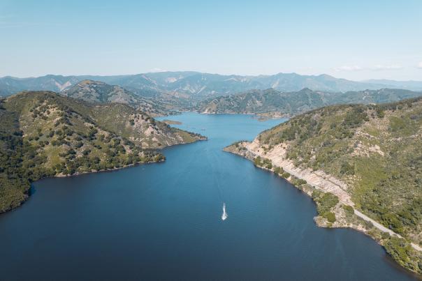 View from above of boat on lake with hills in background