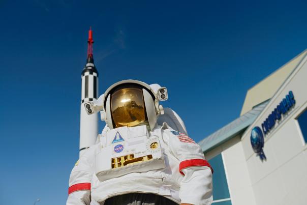 looking up at an astronaut in front of a space museum