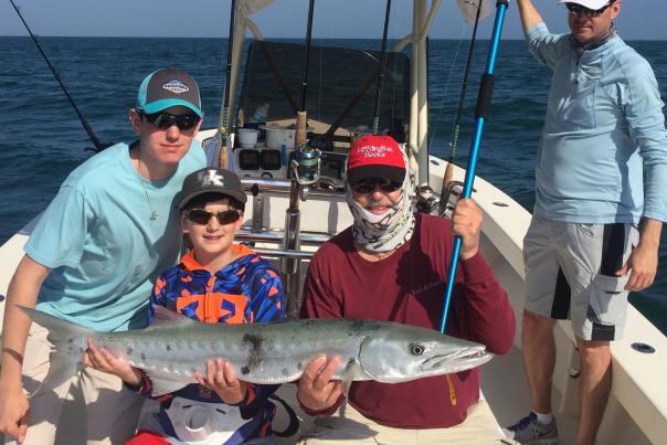 Family fishing trip, showing off a freshly-caught barracuda