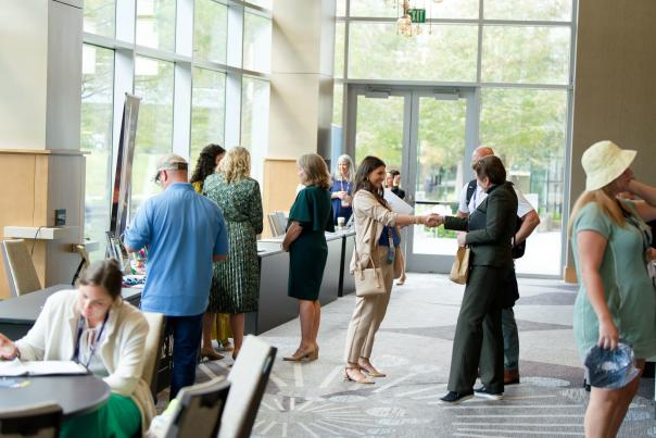 Conference attendees shaking hands during Connect Texas 2023 in The Woodlands, Texas