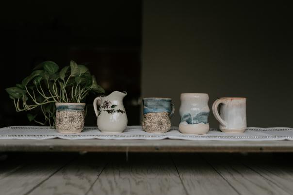 Picture of different pottery creations all lined up in a row from Rise & Design Art Studio.