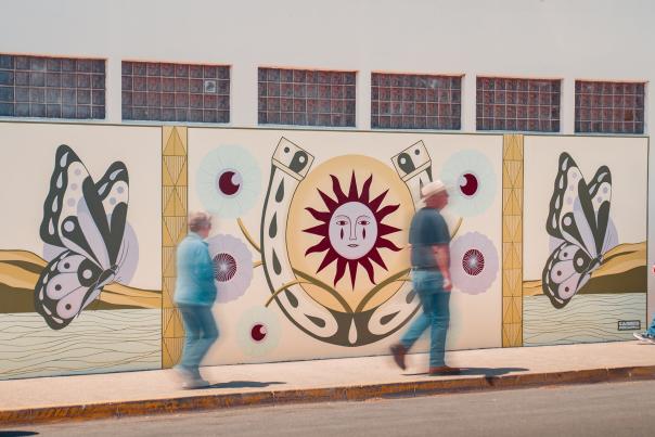 Visitors walking by SLO CAL's "Fly to Her" Mural in Cambria