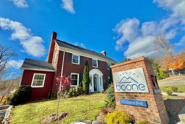 A brick building is behind a large brick sign reading "Explore Boone."
