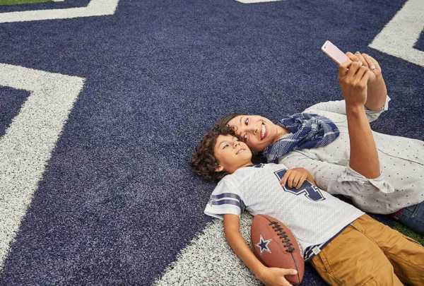 A mother and son take a selfie on the field at AT&T Stadium in Arlington, TX.