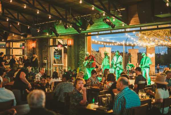 People at a restaurant with open patio concert at Texas Live!