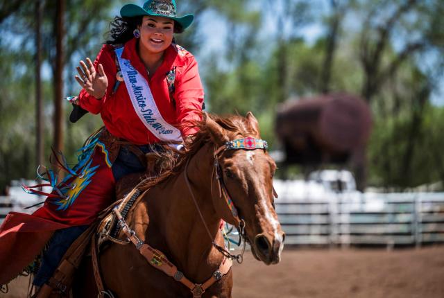 Kaitlyn Maria, crowned New Mexico State Fair Rodeo Queen, rides her horse Manny while waving during the rodeo.