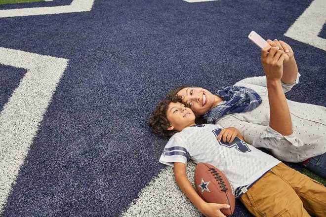 A mother and son take a selfie on the field at AT&T Stadium in Arlington, TX.