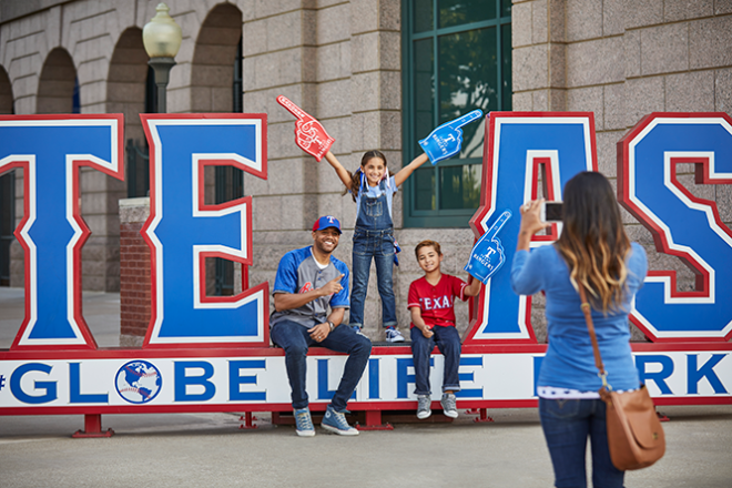 Woman Taking A Picture Of Her Kids By A Texas Sign In Arlington, TX