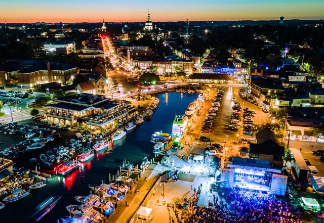 an aerial view of a harbor and waterfront with a stage lit up at night