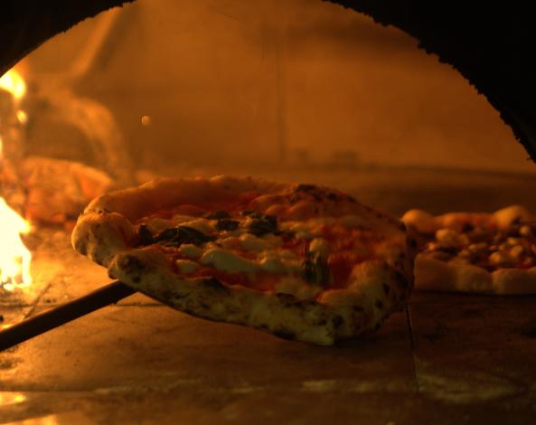 A fresh wood-fired pizza is pulled from the pizza oven at Venturi Pizza.