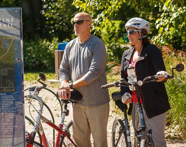 Bikers looking at a trail sign, Pumpkinvine Bike Trail, Elkhart County, Indiana