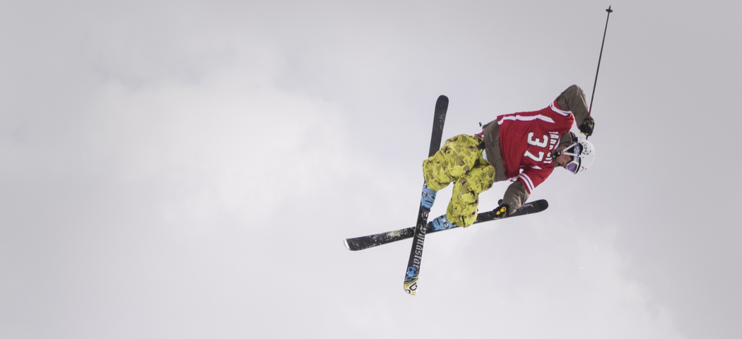 Skier getting big air in a halfpipe over a crowd