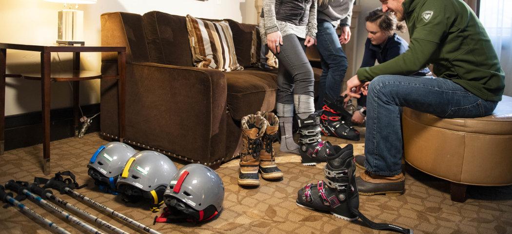 Man helping a women try on ski boots
