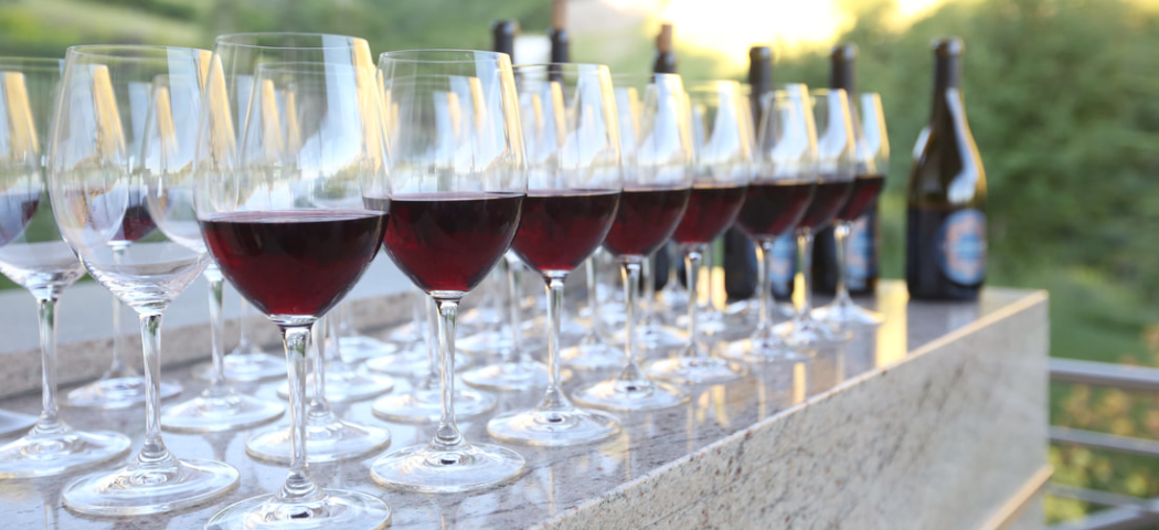 a row of red wine in glasses