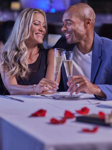 Eddie V's Valentine's Day couple smiling at a table with champagne