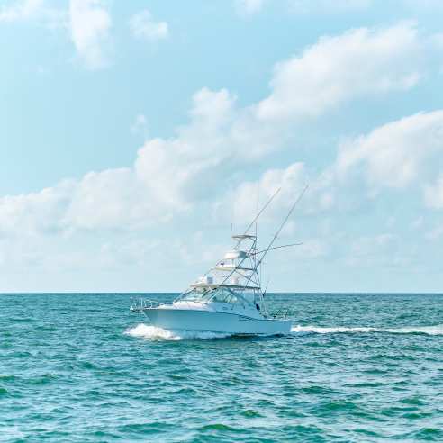 Large white charter boat in turquoise water and bright blue sky