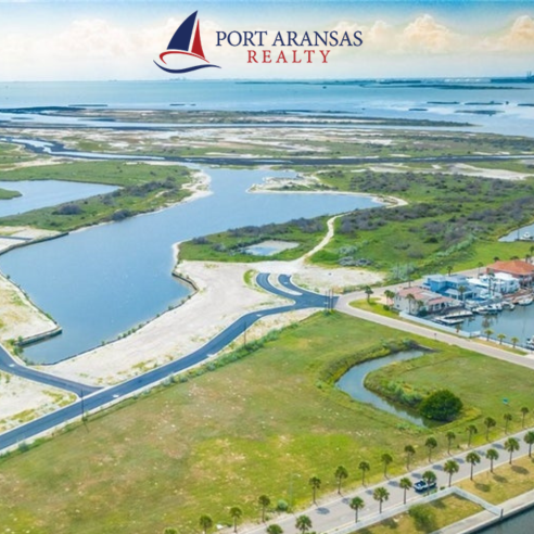 Aerial photo of a beach town with a logo in the top right corner for Port Aransas Realty