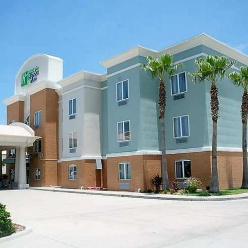 Tan and blue hotel building surrounded by palm trees