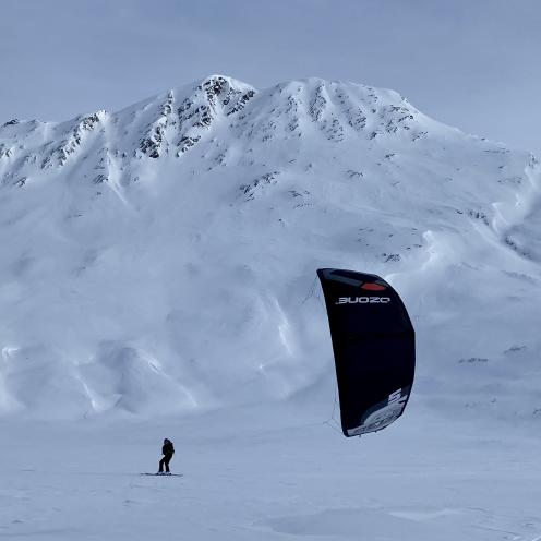 a person snowkiting in a snowy mountain landscape