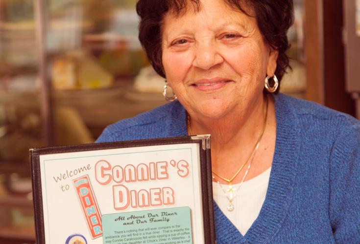 Owner of Connie's Diner holding menu