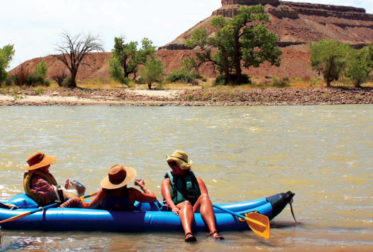 3 people sitting on a blue Kayak on the Green River