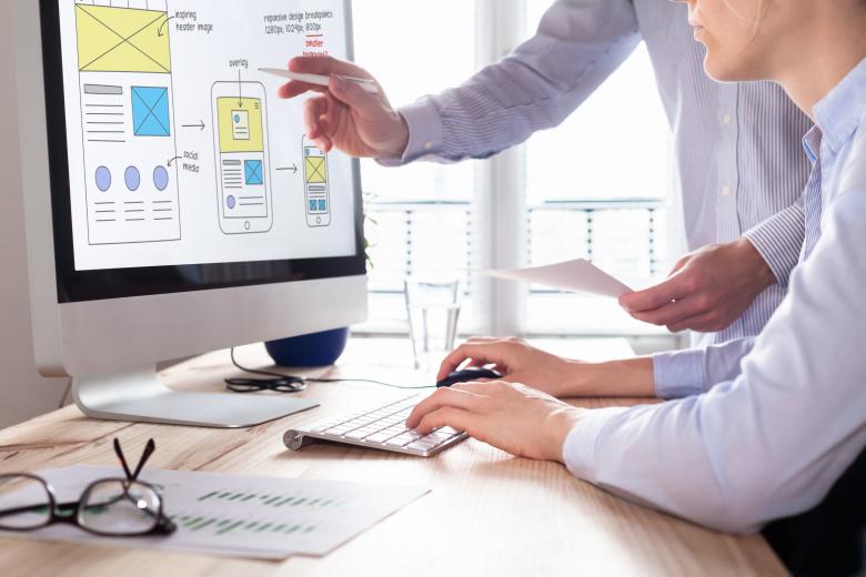 Website development team sketching wireframe layout for responsive web content - stock photo