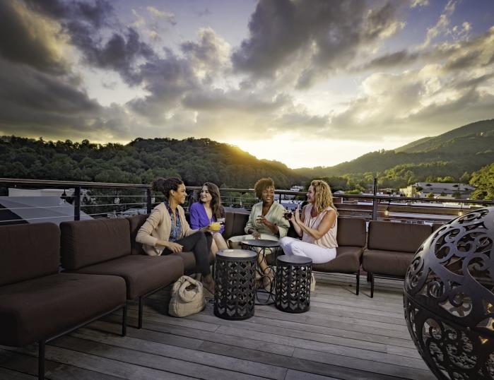 A group of women chat while waiting for sunset on the rooftop at the Horton Hotel.