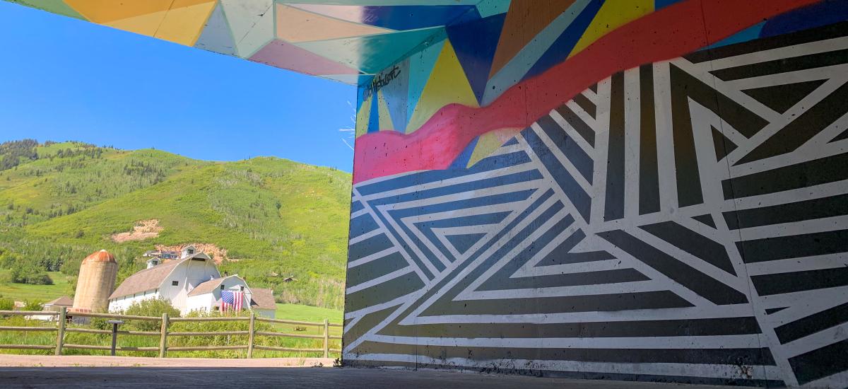 Artists mural in tunnel with the white barn in background
