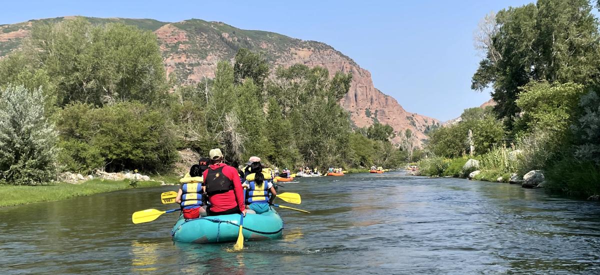 People in rafts floating down a river in a line