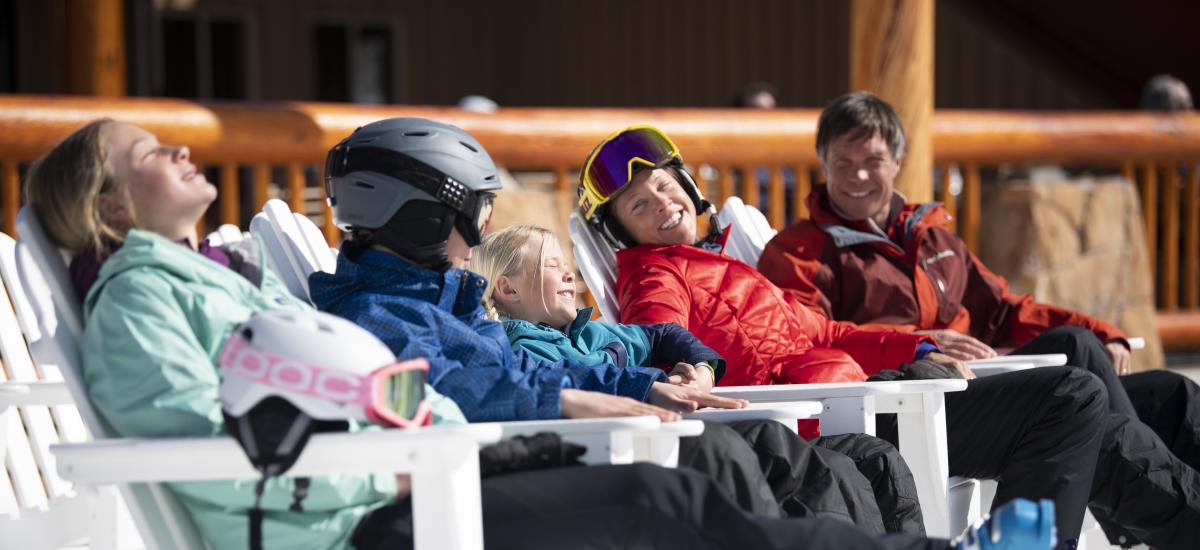 Family sitting on ski beach soaking up the sun